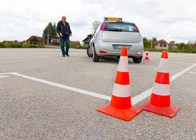 girl-practising-parking-polygon-while-her-instructor-watching-her-from-outside